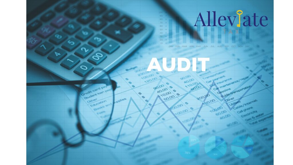 Image of calculator, glasses and business paperwork with the word 'audit" in the center.