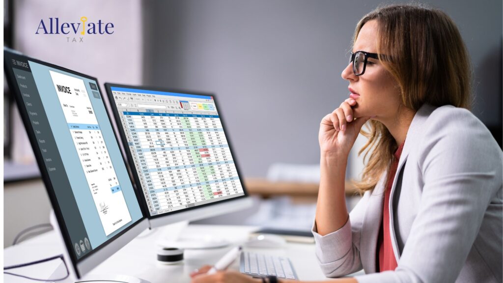 Woman stares at dual computer monitors, confused