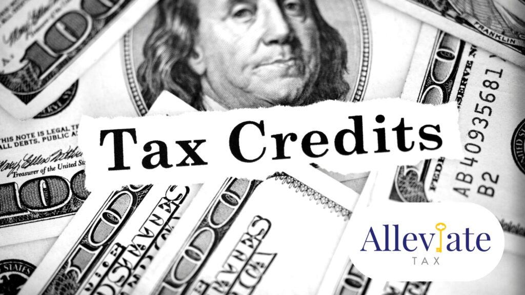 The words tax credits sit above a pile of $100 bills.